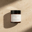 Jar of Radiant Root Face Polish on a beige textured background
