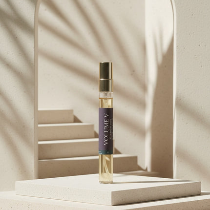 Cologne bottle labeled 'Volume V' on a light beige background